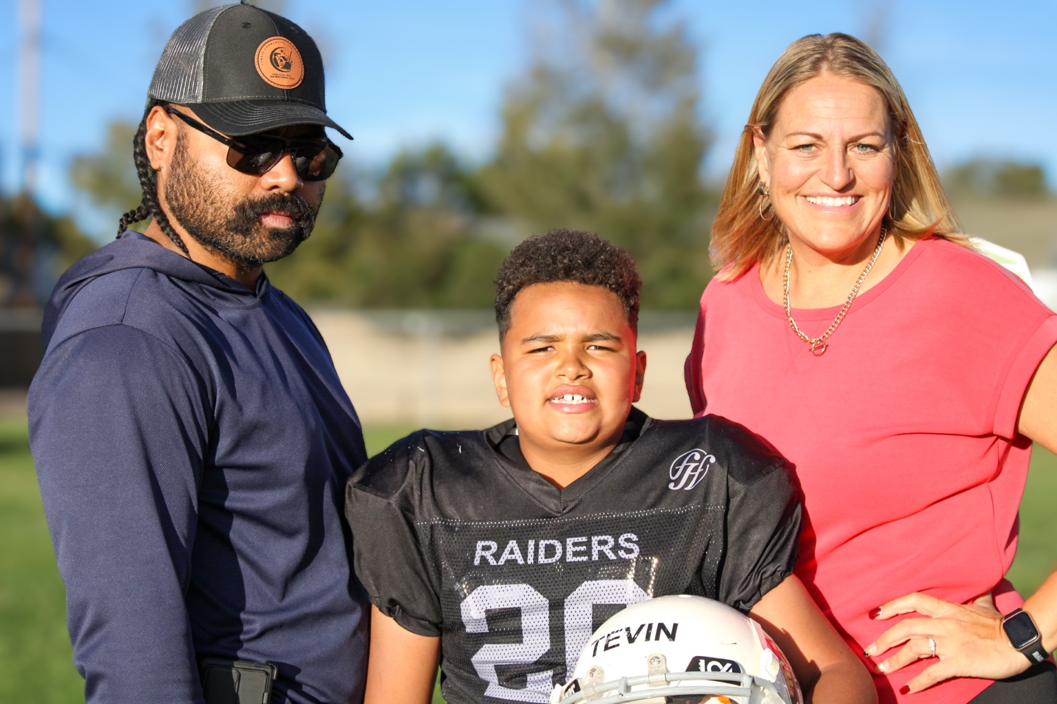 Parents with youth Raiders football player